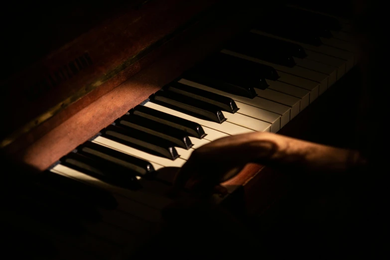 a close up of a person playing a piano, australian tonalism, paul barson, low-light photograph, brown, a wooden