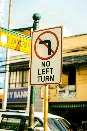 a no left turn sign on a street corner, by Adam Marczyński, unsplash, deconstructivism, philippines, small town, 🚿🗝📝