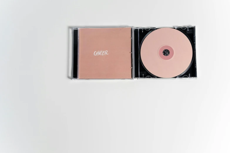 a pink cd sitting on top of a white surface, an album cover, inspired by Caro Niederer, unsplash, computer art, caramel, hozier, healthcare, with a black background