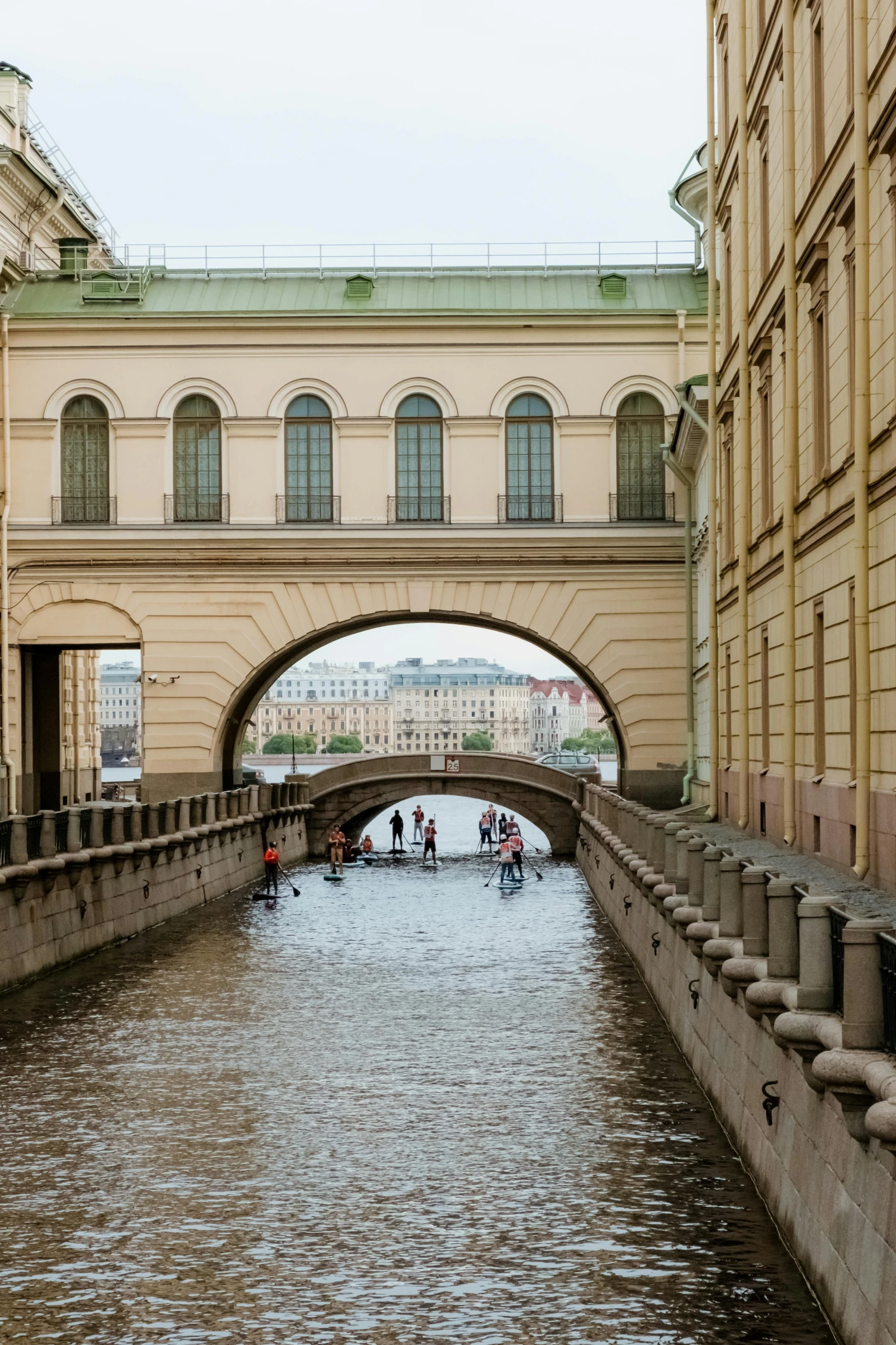 a river running through a city next to tall buildings, renaissance, white sweeping arches, saint petersburg, curved hallways, riding