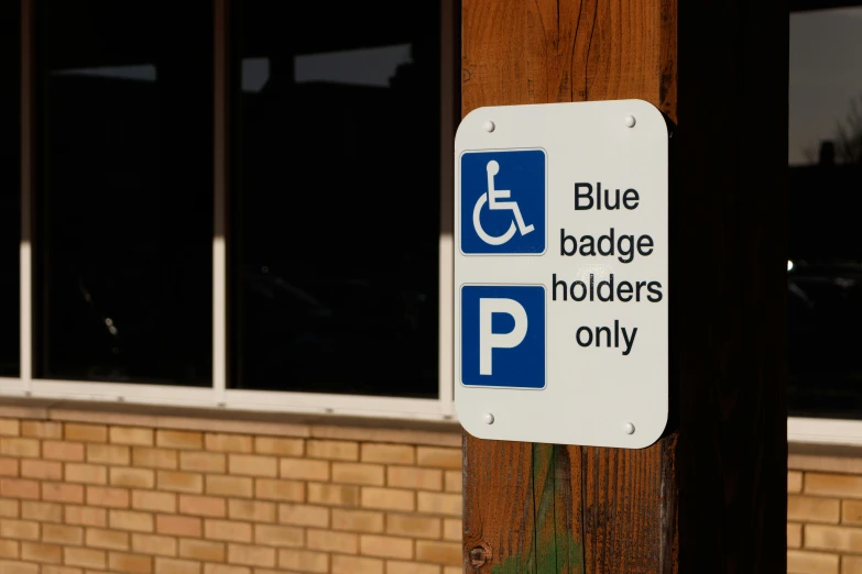 a blue and white sign on a wooden pole, by Paul Bird, unsplash, wheelchair, white holographic plastic, square, premium