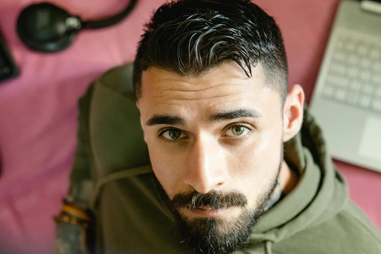 a man with a beard sitting in front of a laptop, a portrait, pexels contest winner, hurufiyya, he got a big french musctache, kurdish soldier, high angle closeup portrait, jacksepticeye
