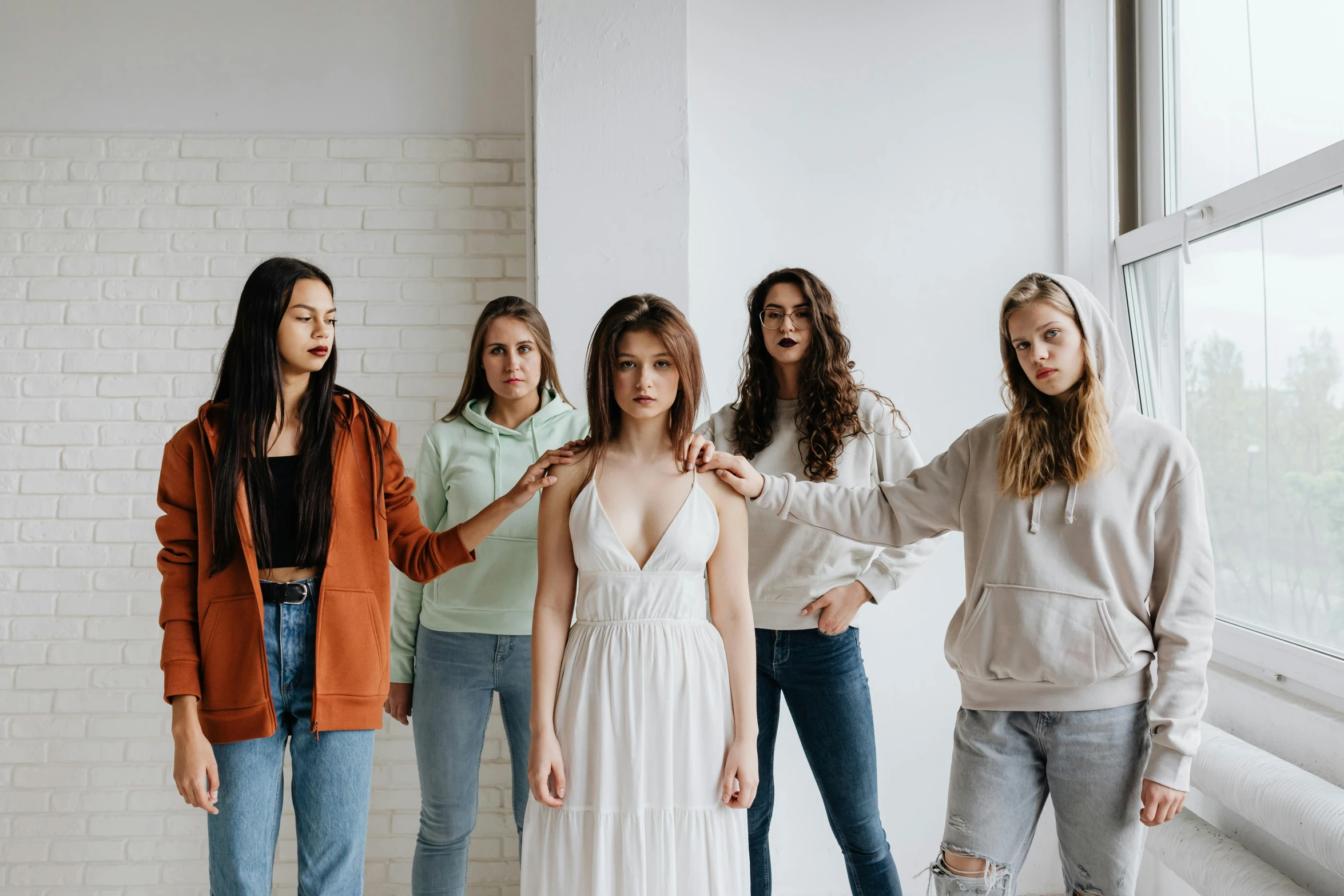 a group of women standing next to each other, a photo, by Emma Andijewska, trending on pexels, renaissance, teenager girl, in white room, background image, multiple stories