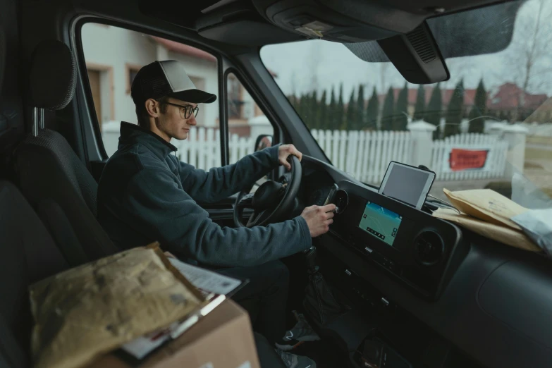 a man sitting in the driver's seat of a truck, pexels contest winner, delivering parsel box, avatar image, front angle, non-binary