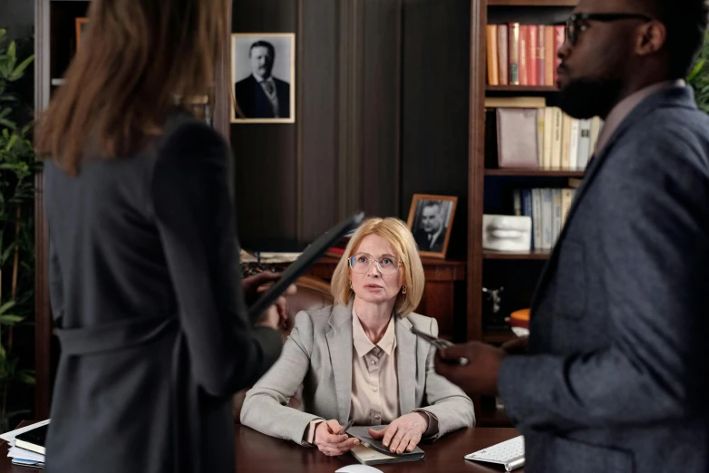 a woman sitting at a desk in front of a man, lawyer suit, ekaterina, anya forger, thumbnail