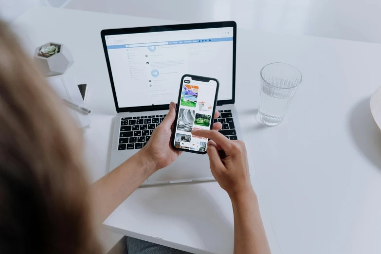 a person sitting at a table with a laptop and cell phone, a picture, trending on pexels, white bg, 9 9 designs, link from zelda using computer, innovative product concepts