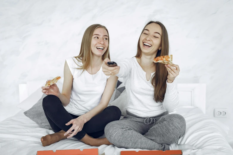 two women sitting on a bed eating pizza, pexels contest winner, avatar image, white background, high school girls, background image