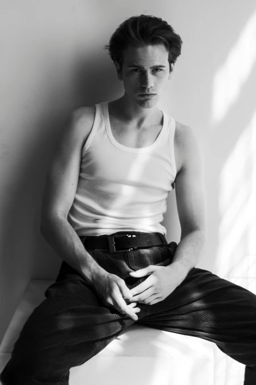 a black and white photo of a man in a tank top, inspired by August Sander, tumblr, tom holland as peter pan, official jil sander editorial, leather, clothed in white shirt