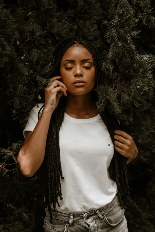 a woman standing in front of a tree talking on a cell phone, inspired by Elsa Bleda, pexels contest winner, renaissance, black hair in braids, portrait of vanessa morgan, wearing a t-shirt, white on black