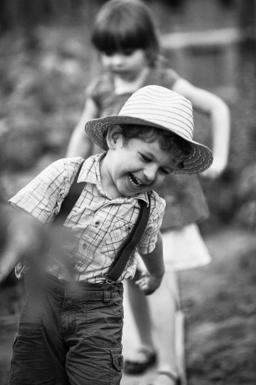 a black and white photo of two children, a black and white photo, pexels contest winner, wearing a straw hat and overalls, he is smiling, walking boy, game