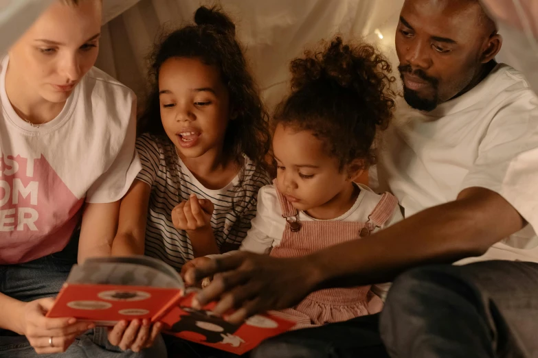 a family reading a book together on a bed, pexels contest winner, avatar image, ( ( dark skin ) ), playing games, profile picture