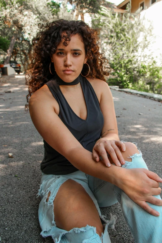 a woman sitting on the ground with a skateboard, trending on pexels, renaissance, she has olive brown skin, hand on her chin, sleeveless, (dark shorter curly hair)