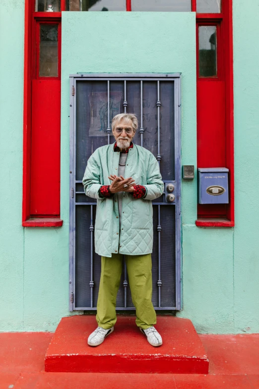 a man that is standing in front of a door, an album cover, by William Berra, pexels contest winner, gray haired, colorful house, green bright red, san francisco