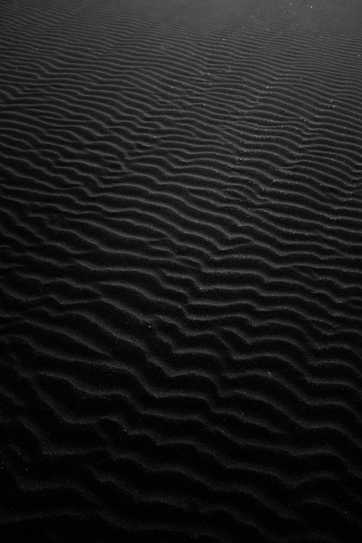 a black and white photo of sand dunes, unsplash, minimalism, dark aesthetic, currents, black paper, dmt ripples
