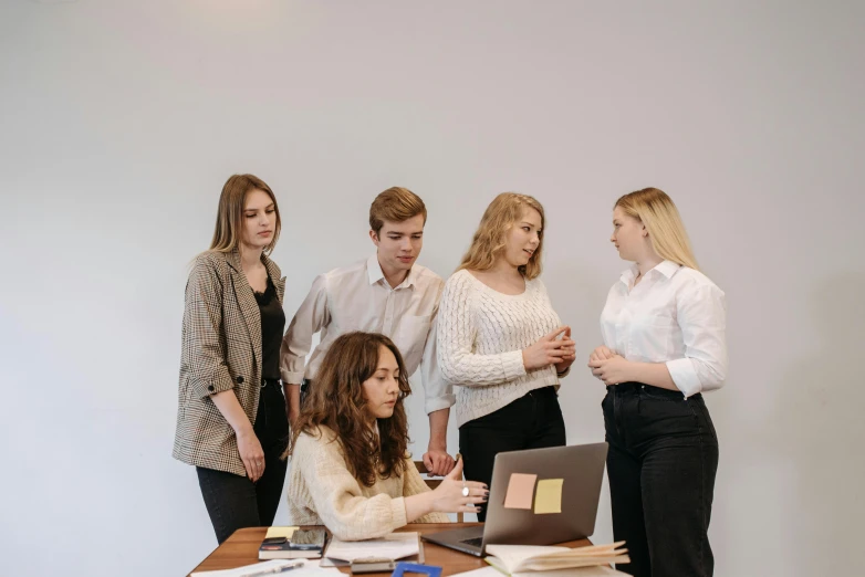 a group of people standing around a table with a laptop, trending on pexels, arbeitsrat für kunst, academic clothing, profile image, college girls, bumps