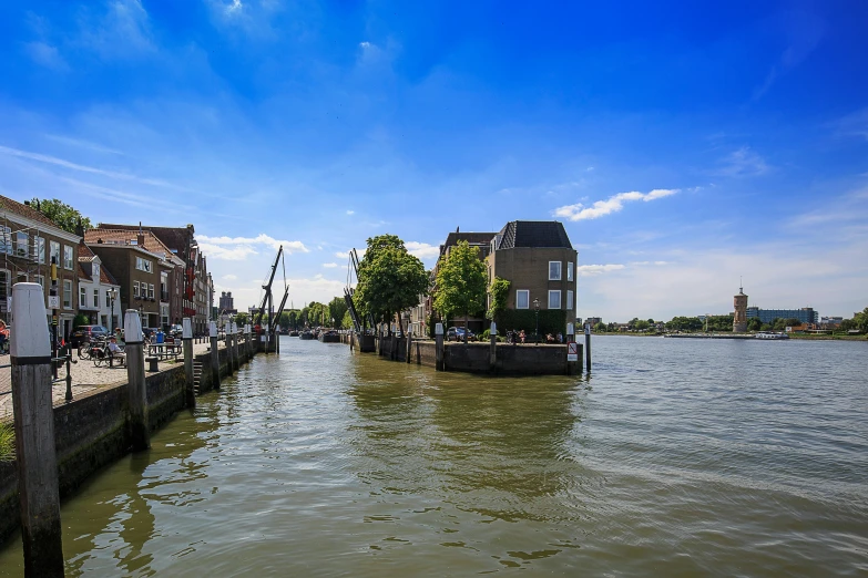 a group of people standing on a dock next to a body of water, by Jan Tengnagel, happening, helmond, massive river, thumbnail, building along a river