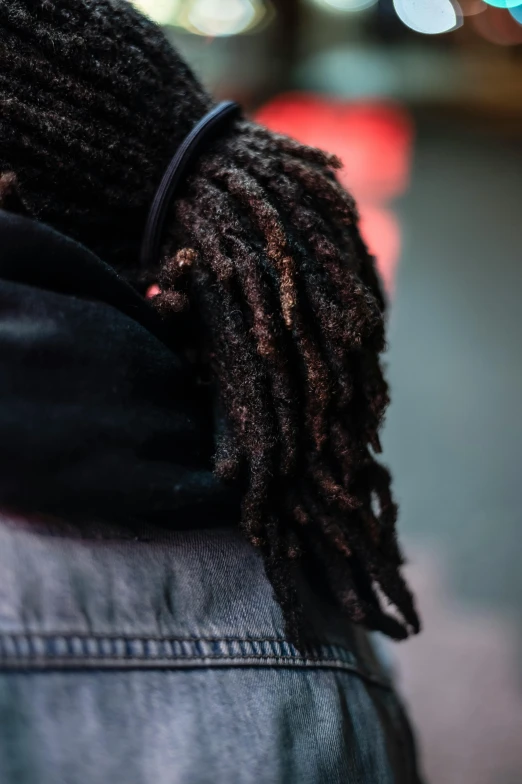a close up of a person with dreadlocks on, trending on pexels, black arts movement, wearing jeans and a black hoodie, over the shoulder view, layered texture, wearing a scarf