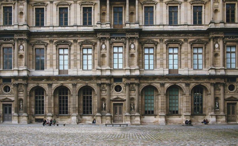 a couple of people sitting on a bench in front of a building, inspired by Thomas Struth, pexels contest winner, paris school, square, palace of the chalice, a wide open courtyard in an epic, 1759