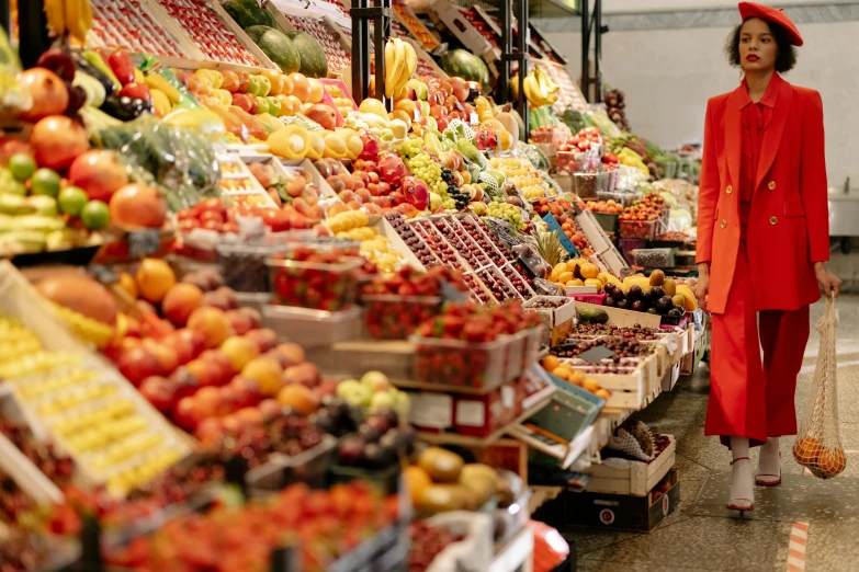 a woman in a red coat standing in front of a fruit stand, pexels, inside a supermarket, multicoloured, wide scene, rectangle