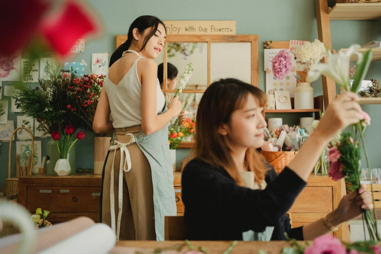 two women are working in a flower shop, by Tan Ting-pho, trending on pexels, arts and crafts movement, avatar image, facing sideways, on a canva, japanese model