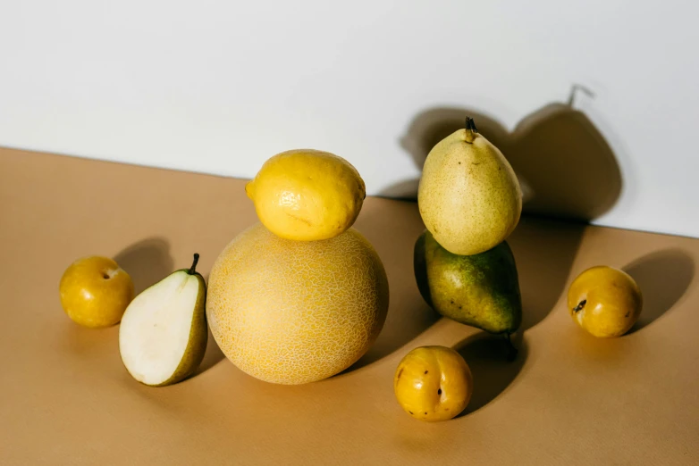 a group of fruit sitting on top of a table, by Doug Ohlson, trending on pexels, light yellow, pear, lecherous pose, full product shot