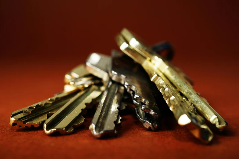 a bunch of keys sitting on top of a table, pexels, on a red background, golden hour closeup photo, ap news photo, stacked image