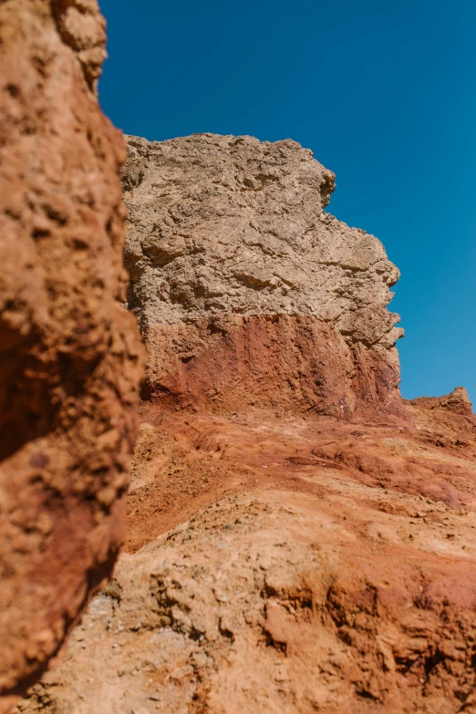 a man riding a motorcycle down a dirt road, an album cover, unsplash, les nabis, red sandstone natural sculptures, geological strata, agrigento, coloured photo