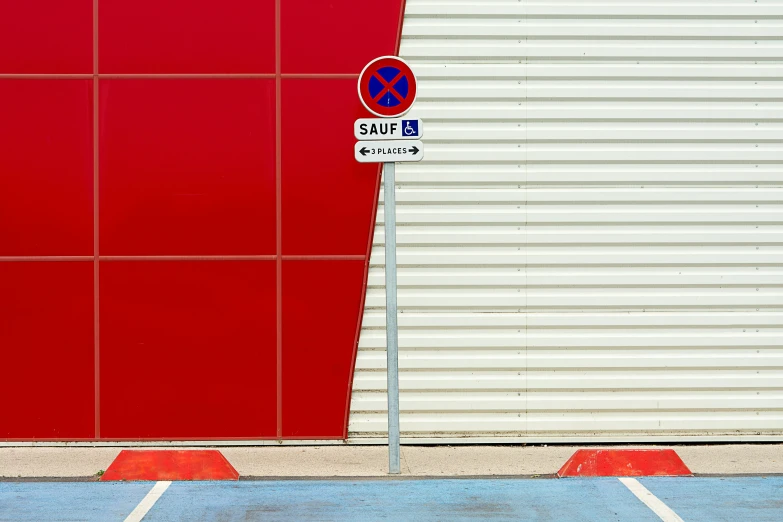 a no parking sign in front of a red building, inspired by Bauhaus, unsplash, postminimalism, square lines, demur, seville, metal panels