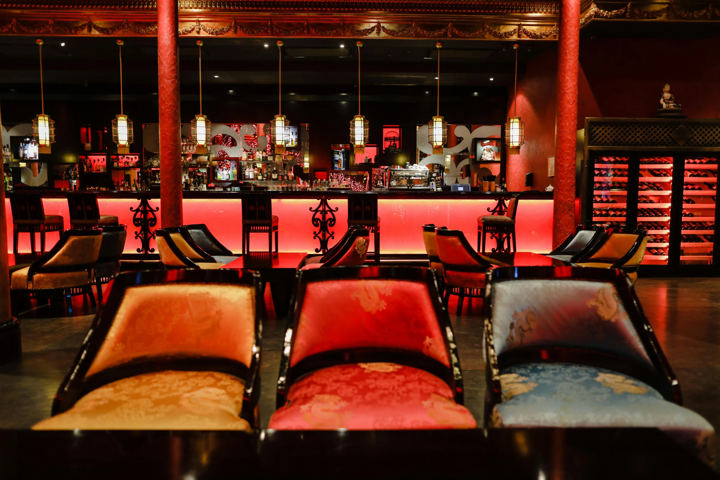 a group of chairs sitting in front of a bar, chinese empress, red lights, lounge, vibrant colour