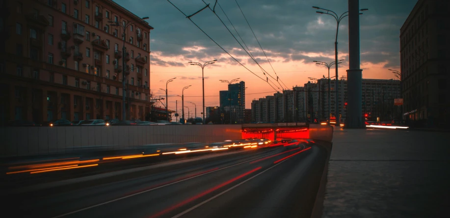 a street filled with lots of traffic next to tall buildings, by Alexander Runciman, pexels contest winner, moscow metro, orange and red lighting, 000 — википедия, spring evening