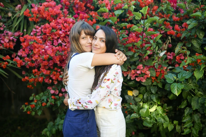 a couple of women standing next to each other, a portrait, by Julia Pishtar, lush plants and flowers, hug, 15081959 21121991 01012000 4k, vine