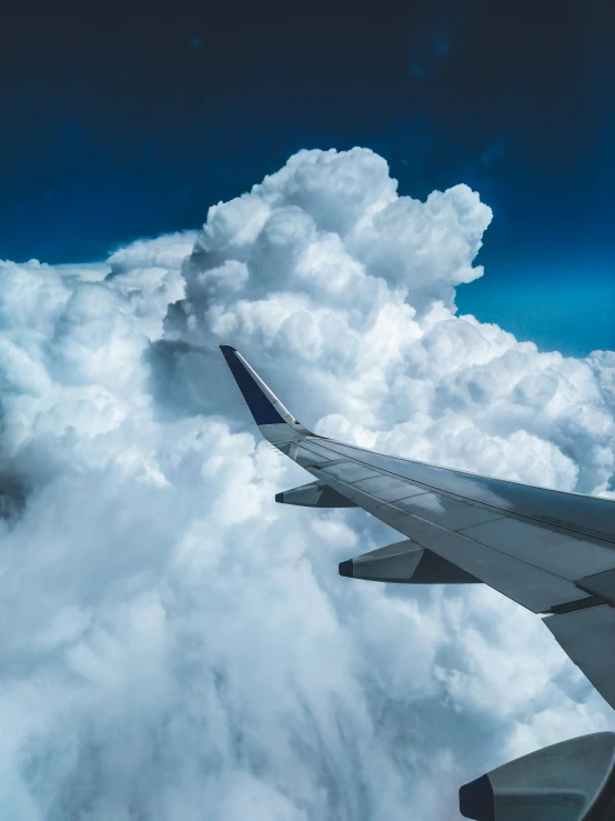 the wing of an airplane flying above the clouds, an album cover, pexels contest winner, thunderclouds, profile picture, conde nast traveler photo, turbulent