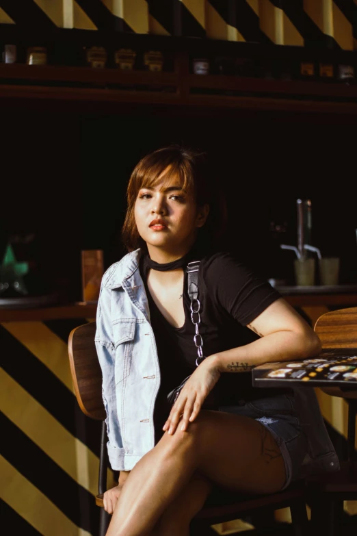 a woman sitting at a table in a kitchen, a portrait, inspired by Elsa Bleda, trending on pexels, realism, at a bar, brown hair and bangs, cinematic outfit photo, joy ang