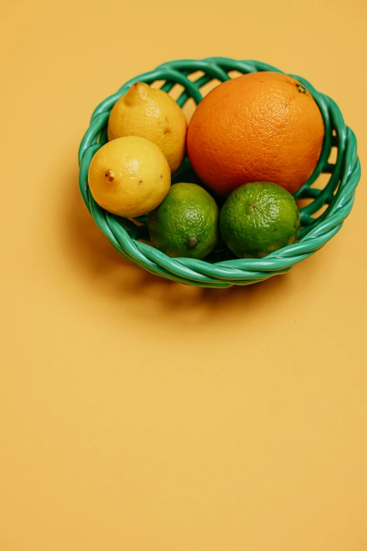 a green basket filled with oranges and lemons, a still life, pexels, multiple stories, multi - coloured, minimalistic composition, orange: 0.5