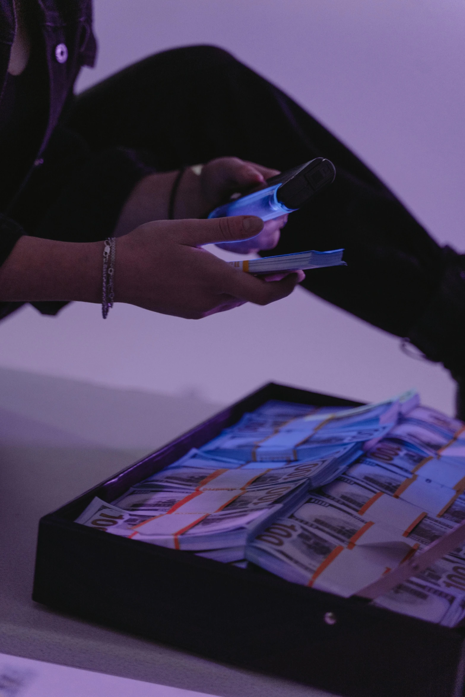 a woman sitting on the floor looking at her cell phone, a hologram, by artist, piles of money, virgil abloh, purple ambient light, zoomed view of a banknote