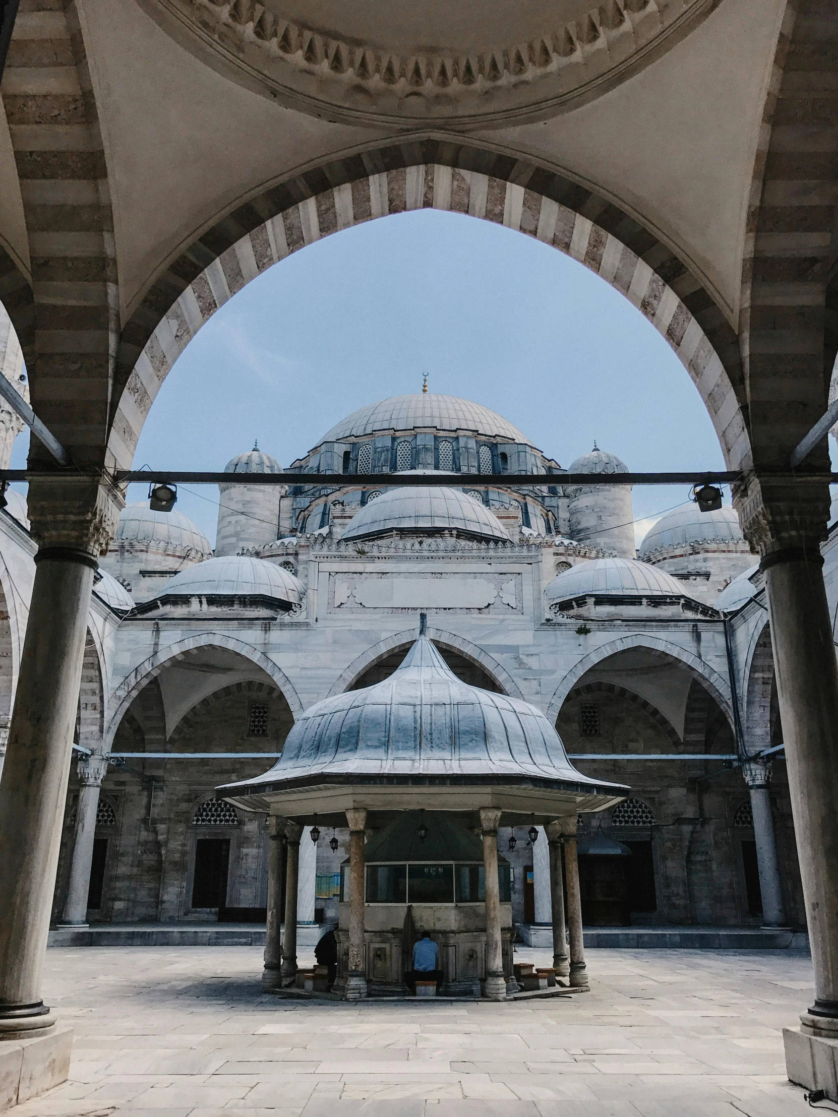 the inside of a building with columns and a dome, inspired by Osman Hamdi Bey, pexels contest winner, outside, square, tiled roofs, grey