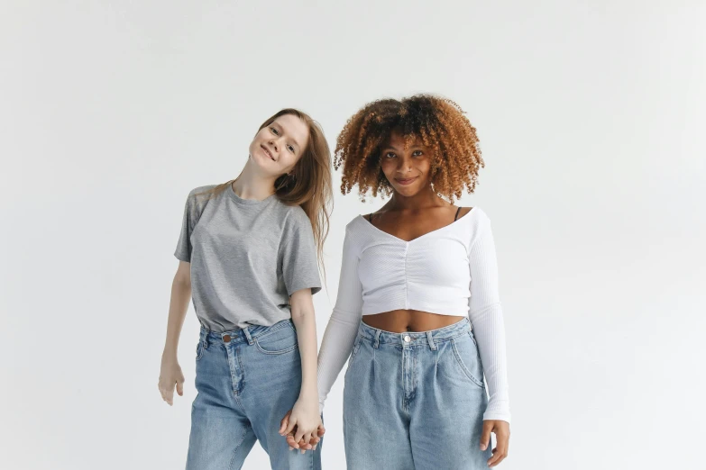 a couple of women standing next to each other, trending on pexels, renaissance, croptop, ( ( ( wearing jeans ) ) ), small wide smile, reaching out to each other