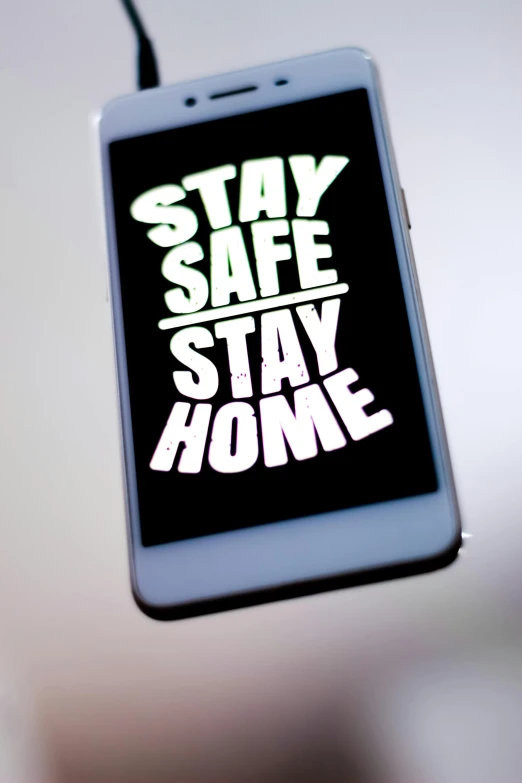 a cell phone with the words stay safe stay home on it, shutterstock, ap, 2506921471