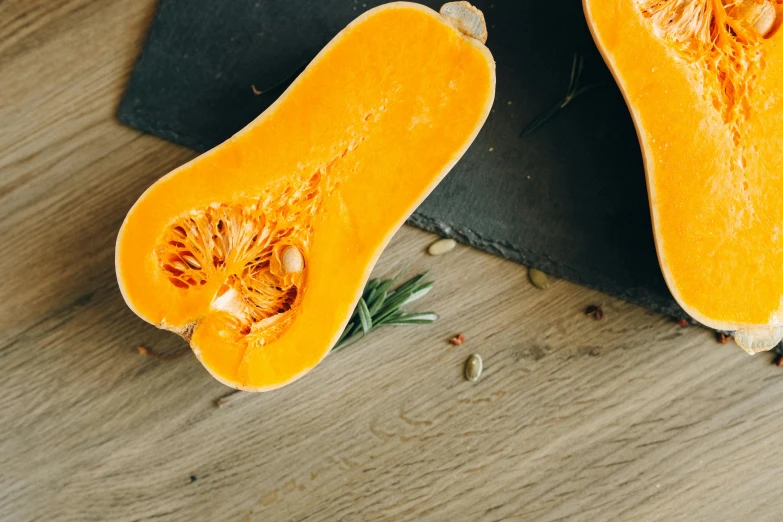 a butternut cut in half on a cutting board, unsplash, background image, slate, 🦩🪐🐞👩🏻🦳, yellow-orange