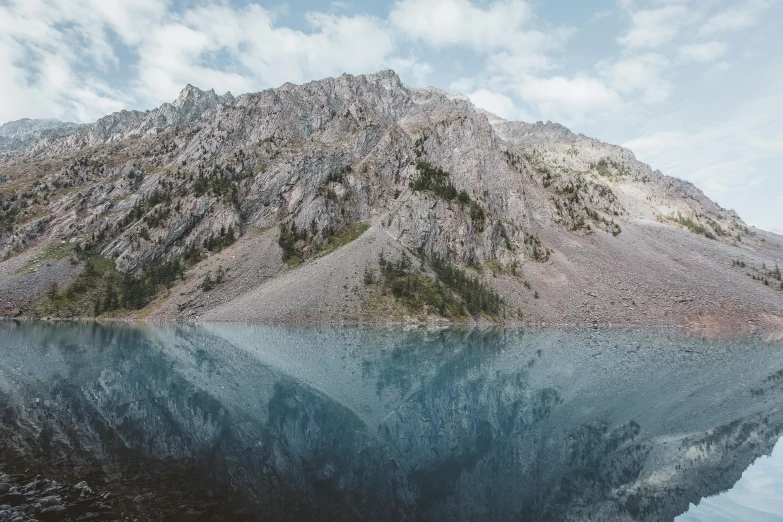 a body of water with a mountain in the background, a picture, by Morgan Russell, unsplash contest winner, magical realism, water mirrored water, ultra high detailed, cut into the side of a mountain, stagnant water