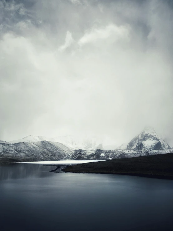 a large body of water surrounded by snow covered mountains, inspired by Pierre Pellegrini, minimalism, jingna zhang, holga hasselblad, eduard pronin, dark image