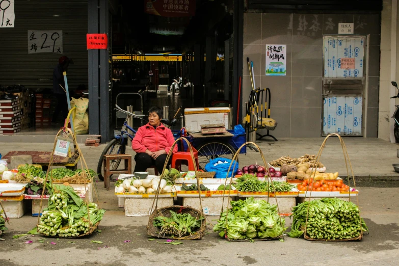 a woman sitting in front of a fruit and vegetable stand, inspired by Cui Bai, pexels contest winner, square, baotou china, green alleys, avatar image