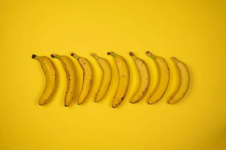 a row of bananas sitting on top of a yellow surface, multiple stories, unedited, grey, recipe