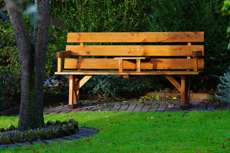 a wooden bench sitting on top of a lush green field, lawns, in the sun, low - lighting, gardens