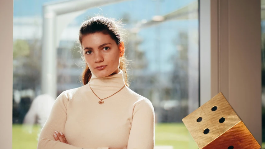 a woman standing in front of a wooden block, by Emma Andijewska, wearing several pendants, angela sarafyan, wearing turtleneck, very award - winning