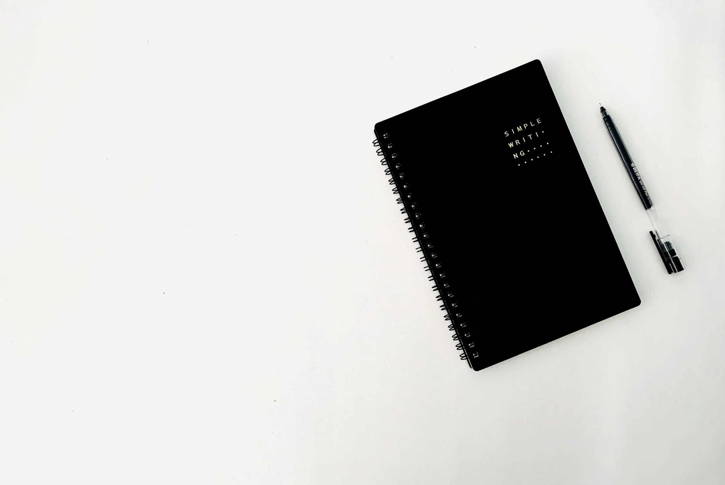 a black notebook with a pen on top of it, by Matija Jama, pexels contest winner, minimalism, white backround, full-body, planning, black