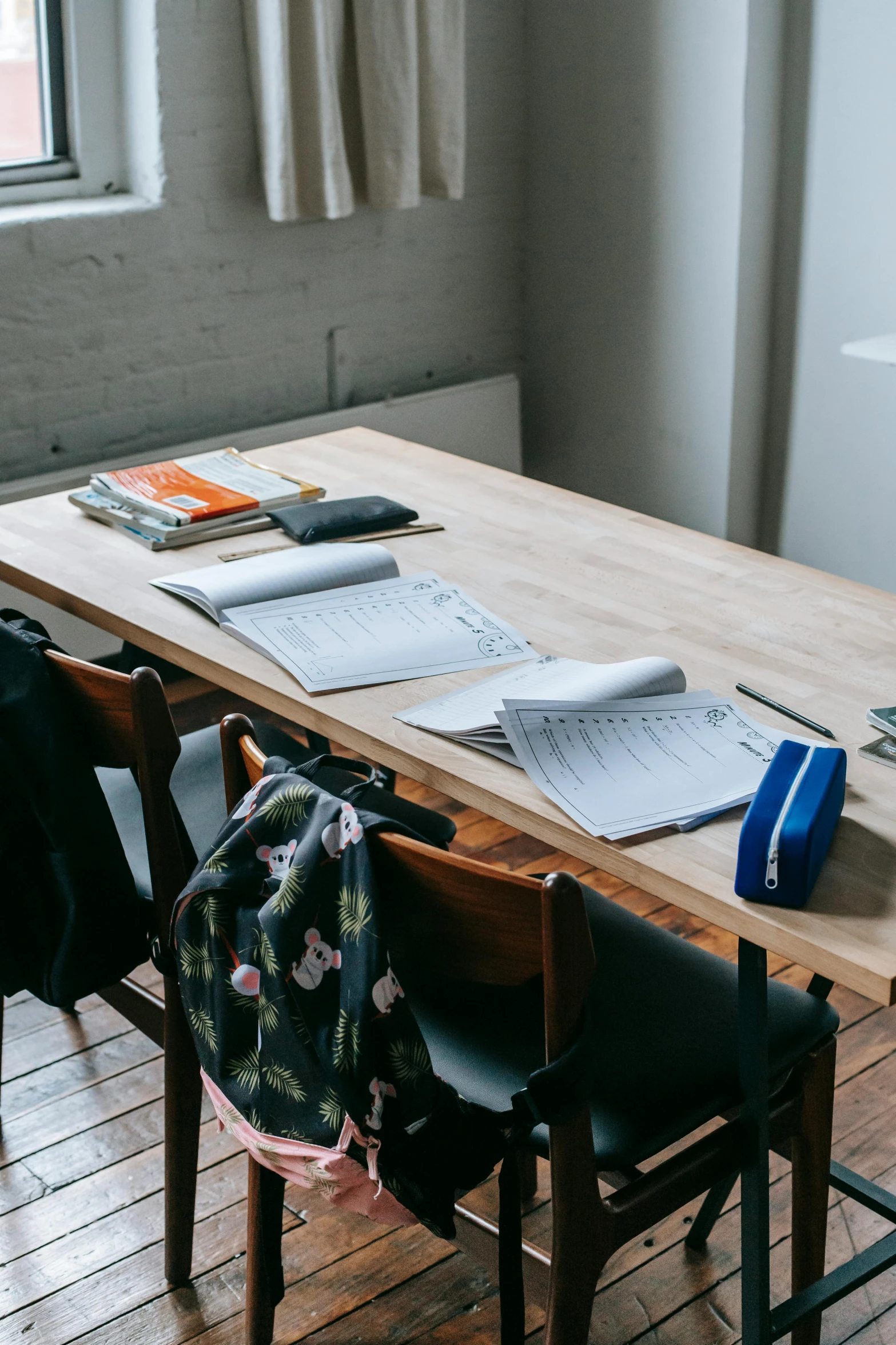 a wooden table topped with lots of books, academic art, two plastic chair behind a table, background image, wetastudiofx, charts