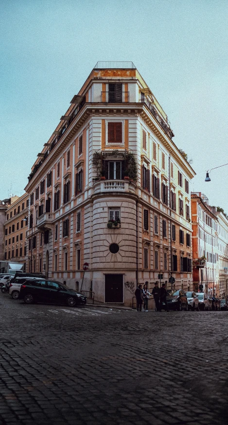 a very tall building sitting on the side of a street, by Alessandro Allori, pexels contest winner, neoclassicism, panorama view, profile image, street corner, built on a steep hill