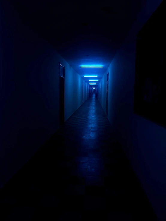 a long hallway with a light at the end of it, an album cover, inspired by Elsa Bleda, unsplash contest winner, postminimalism, dark blue neon light, ignant, taken on iphone 14 pro, ((blue))