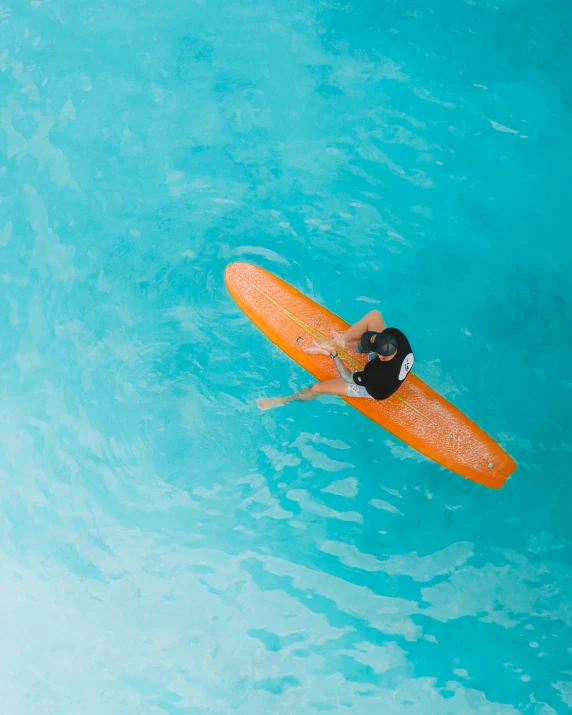 a person on a surfboard in the water, pexels contest winner, cyan and orange, in a luxurious pool, thumbnail, canoe